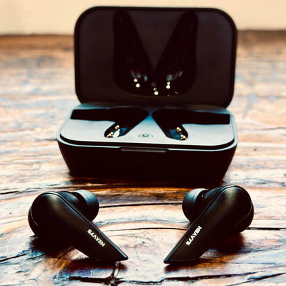 Black wireless earbuds with charging case on a wooden surface